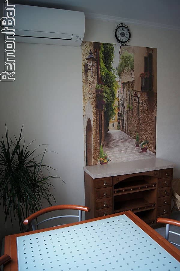 На стене -декоративная "фреска" (раньше это называлось "фотообои", только фреска отличается фактурой). Обои в кухне светлые с бежевым оттенком.