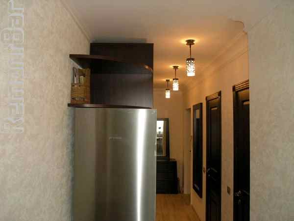 Холодильник и несколько полок с кухонными приборами расположены как бы в коридоре, хотя доступ к ним из кухни нисколько не затруднен. Это позволило сделать кухню просторнее.