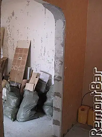 Коридор от прихожей до ремонтных работ отделялся широкой аркой. Собственно, для реализации дизайн-проекта, конструкцию можно было и оставить. Но вызывало некое сомнение качество перегородки. Она была построена из пенобетонных блоков (вроде бы все нормально), но необходимую толщину добрали не штукатуркой, а гипсокартонными листами, которые отслаивались. Качество самой кладки так же было сомнительным, между блоками были заметны трещины. Поэтому...