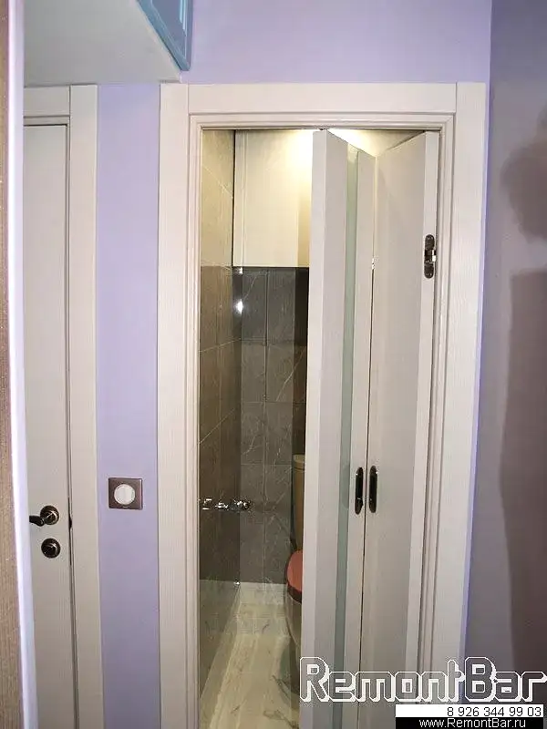 Вход в туалет расположен так, что разгуляться тут негде. К тому же, до ремонта прямо перед дверью располагался компактный книжный шкафчик, к которому заказчик очень привык и не собирался от него отказываться Дверь заслуживает особого внимания