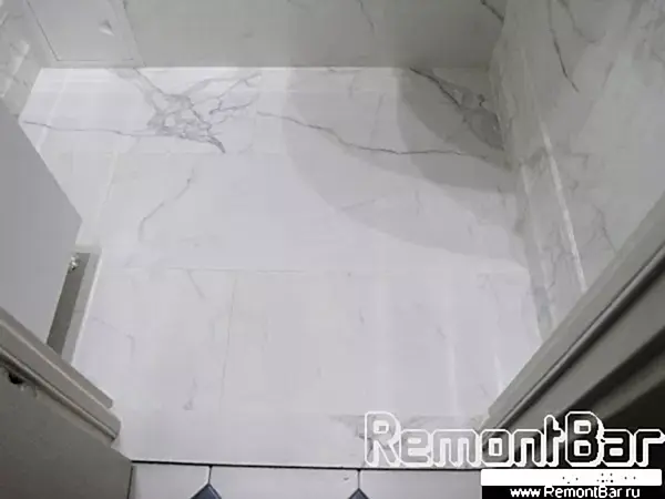 Пол - похожая на стеновую плитка "под мрамор". Широкоформатные плиты уложены вразбежку. Примыкание стены к полу - кемогранитный плинтус из этой же коллекции Пол - похожая на стеновую плитка "под мрамор". Широкоформатные плиты уложены вразбежку. Примыкание стуны к полу - кемогранитный плинтус из этой же коллекции.