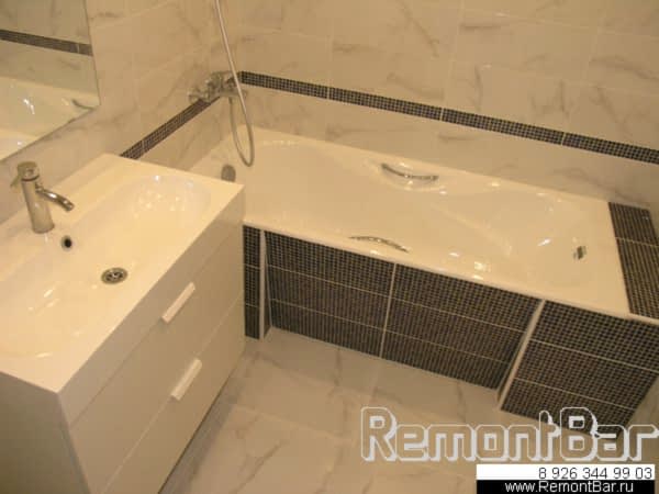 Экран под ванной - с косой нишей. Для его облицовки использовалась плитка другого тона и рисунка, нежели для облиовки стен (здесь она из той же коллекции, но рисунок имитирует мозаику, так же, как и плоский бордюр по периметру комнаты)